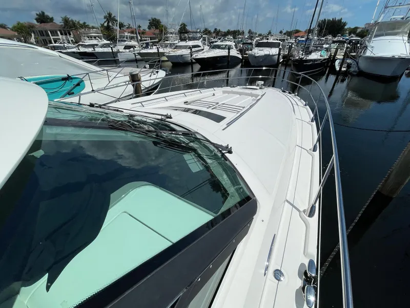 Slide: The Image of 2010 Sea Ray 540 Sundancer yacht docked in a marina, surrounded by other boats. - 11