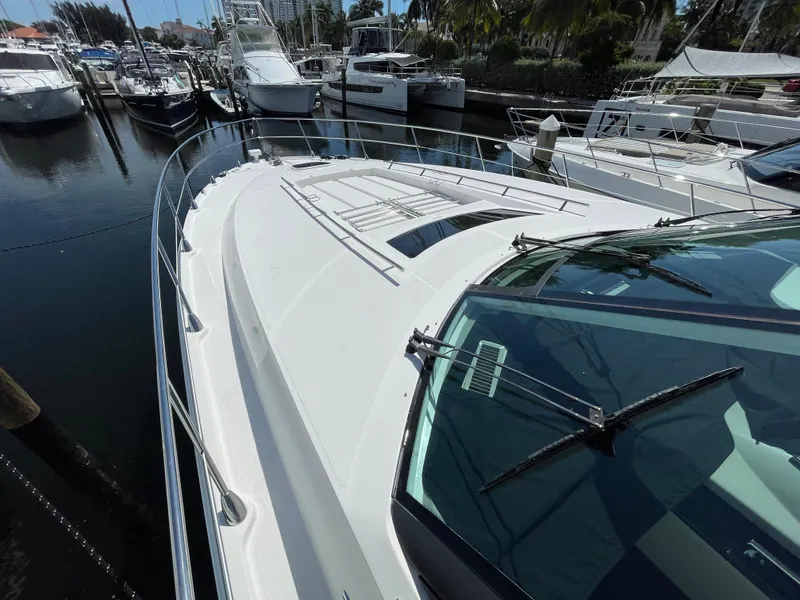 Slide: The Image of 2010 Sea Ray 540 Sundancer yacht docked at marina, showcasing sleek design and spacious deck. - 12