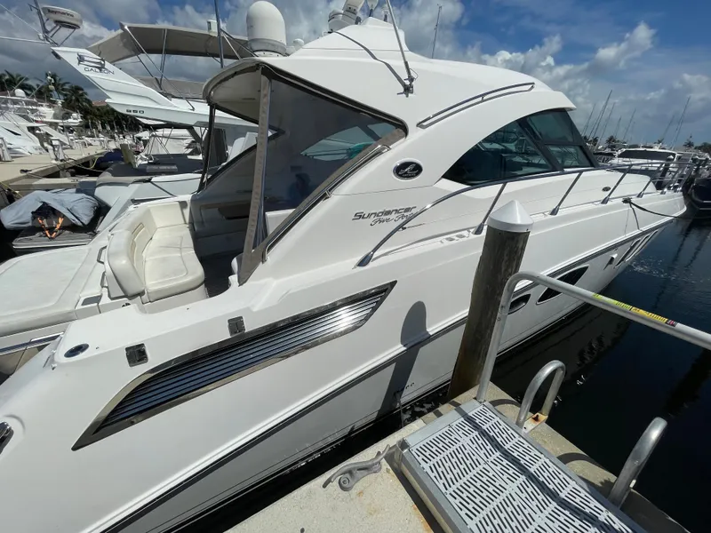 Slide: The Image of 2010 Sea Ray 540 Sundancer yacht docked at marina under clear sky. - 13