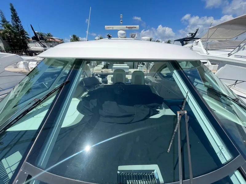 Slide: The Image of 2010 Sea Ray 540 Sundancer yacht with sleek windshield and modern design, docked under blue sky. - 9