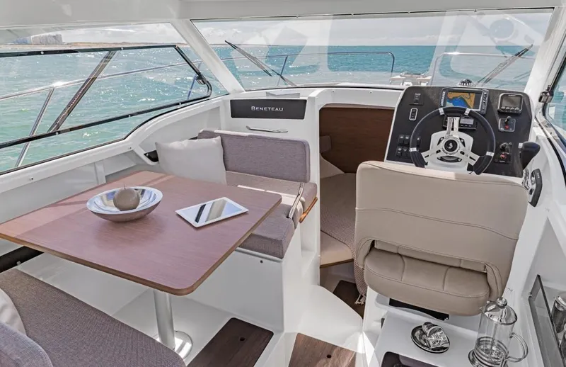Slide: The Image of 2025 Beneteau Antares 8 interior with helm, dining area, and sea view. - 3
