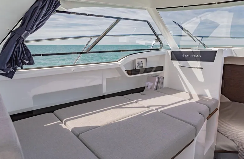 Slide: The Image of 2025 Beneteau Antares 8 interior with cushioned seating and ocean view. - 6