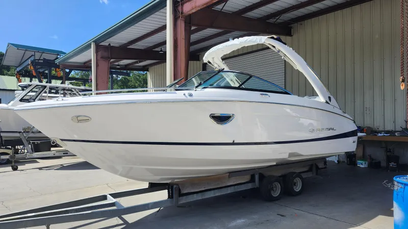 Slide: The Image of 2026 Regal LX4 boat on calm water, sleek white design, modern features. - 1