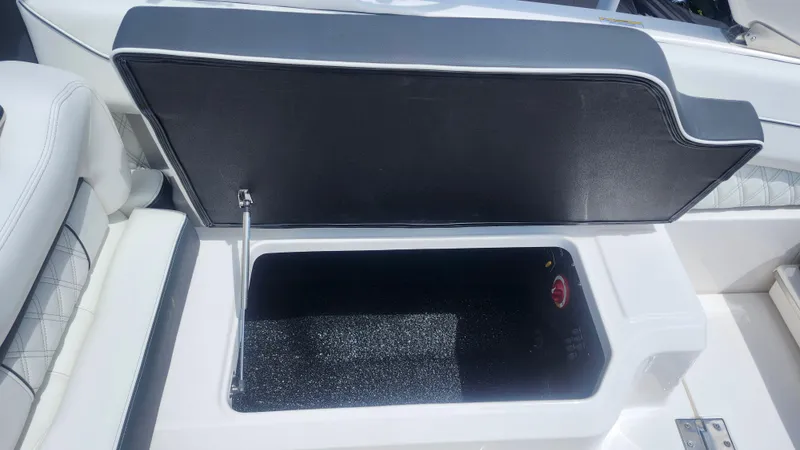 Slide: The Image of Open storage compartment on 2026 Regal LX4 boat, featuring sleek white and black design. - 13