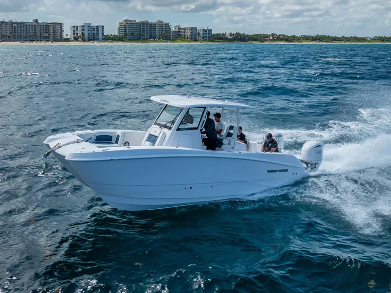 Slide: The Image of 2026 Twin Vee 260 GFX2 CC cruising on open ocean under cloudy sky. - 10