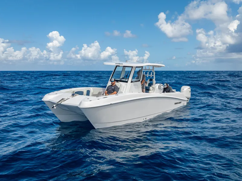 Slide: The Image of 2026 Twin Vee 260 GFX2 CC boat cruising on open ocean under clear skies. - 15