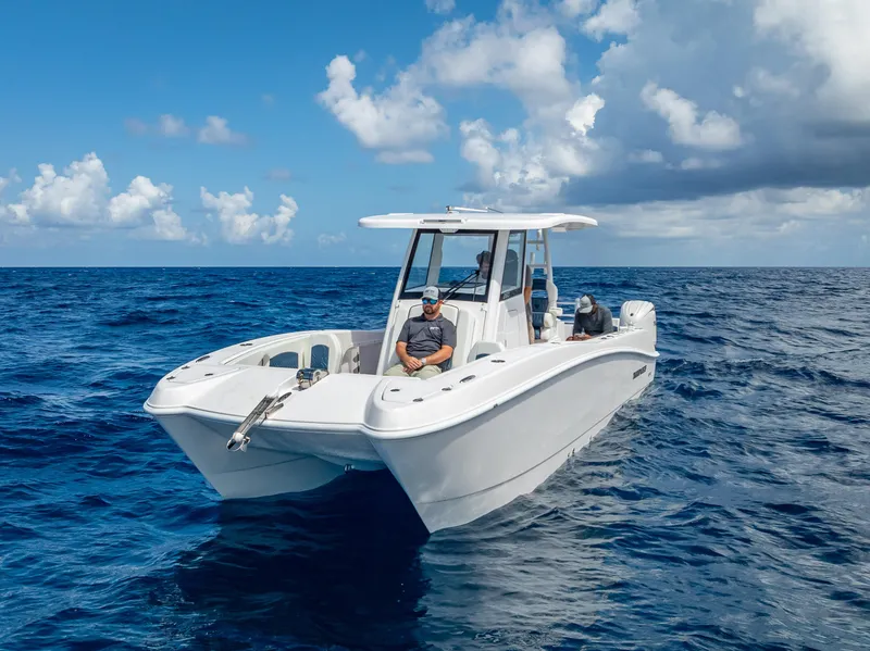 Slide: The Image of 2026 Twin Vee 260 GFX2 CC boat cruising on open ocean under cloudy sky. - 16