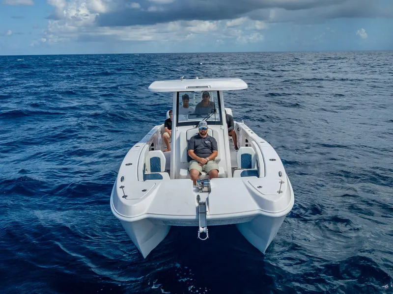 Slide: The Image of 2026 Twin Vee 260 GFX2 CC boat cruising on open ocean under cloudy sky. - 17