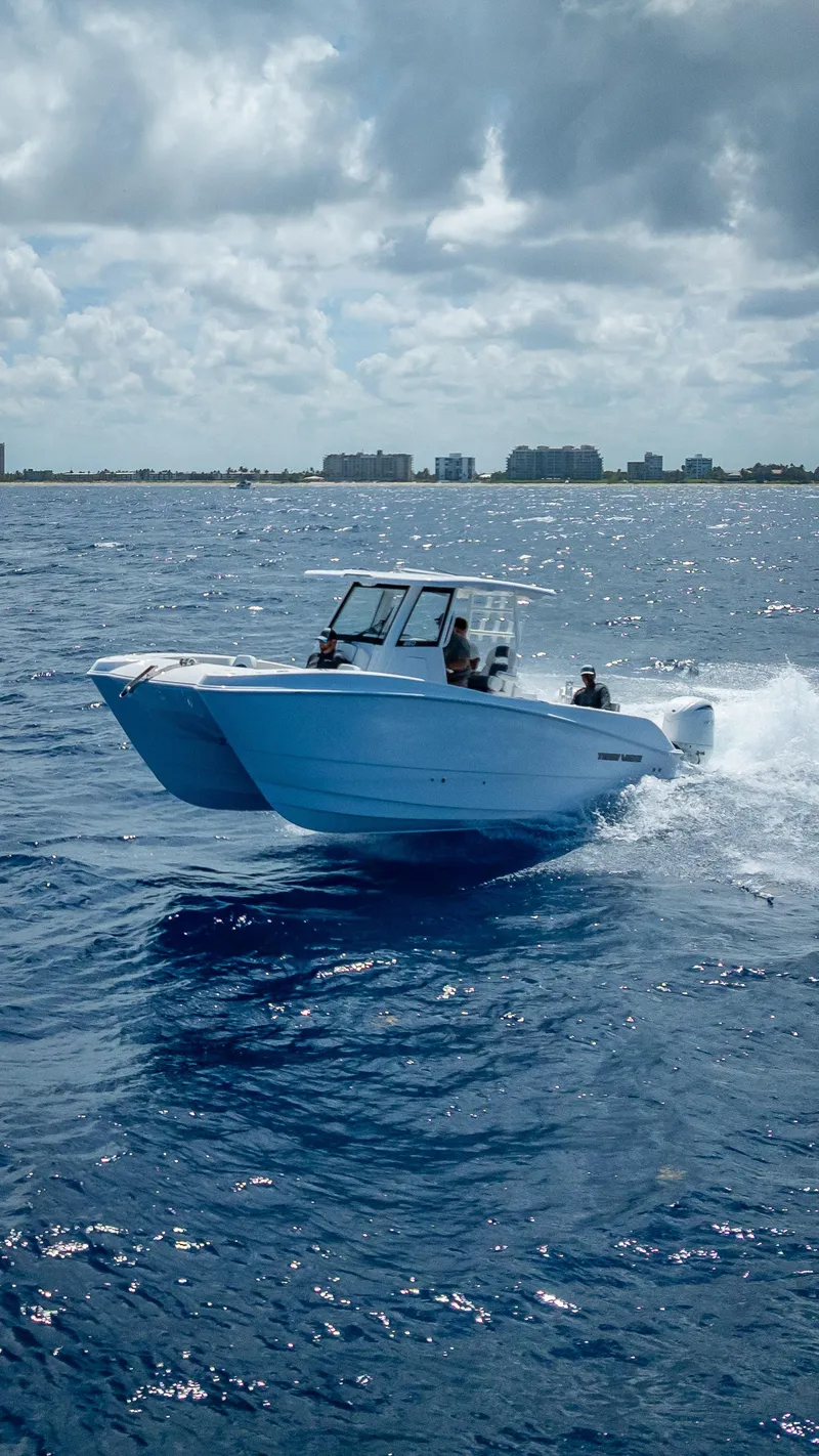 Slide: The Image of 2026 Twin Vee 260 GFX2 CC cruising on open ocean under clear skies. - 2