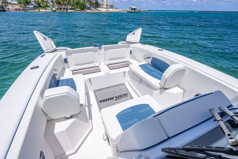 Slide: The Image of 2026 Twin Vee 260 GFX2 CC boat interior with seating, open hatches, and ocean view. - 29