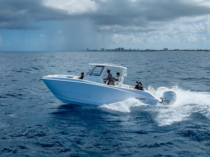 Slide: The Image of 2026 Twin Vee 260 GFX2 CC boat cruising on open ocean under cloudy sky. - 3