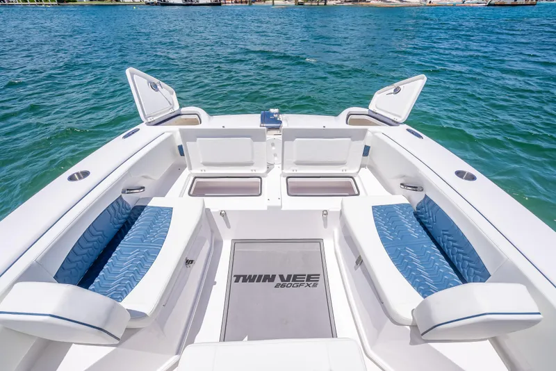 Slide: The Image of 2026 Twin Vee 260 GFX2 CC boat interior with blue seating and open storage compartments. - 30