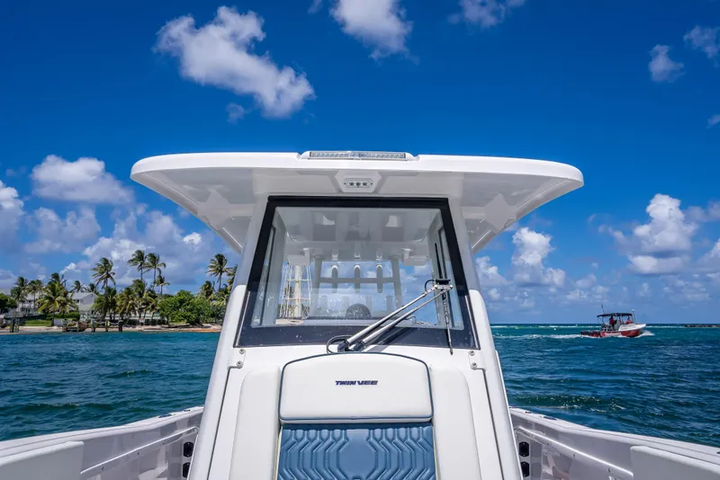 Slide: The Image of 2026 Twin Vee 260 GFX2 CC boat on ocean, clear sky, palm trees in background. - 31
