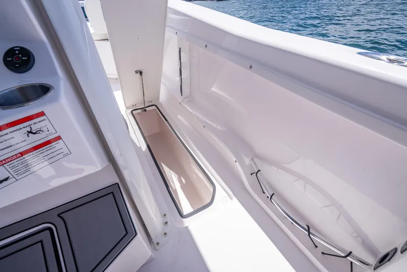 Slide: The Image of 2026 Twin Vee 260 GFX2 CC boat interior with storage compartment and safety instructions. - 34