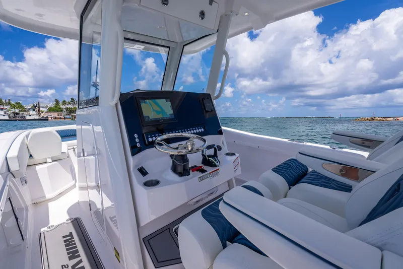 Slide: The Image of 2026 Twin Vee 260 GFX2 CC boat interior with steering console and ocean view. - 47