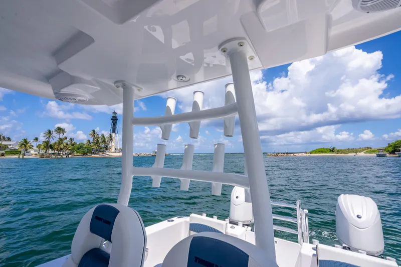 Slide: The Image of 2026 Twin Vee 260 GFX2 CC boat on water near lighthouse and palm trees. - 49