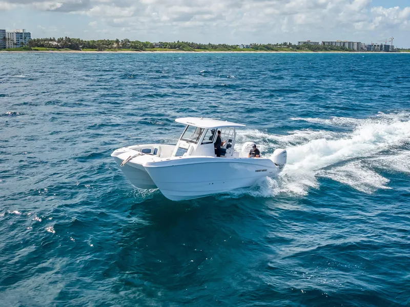 Slide: The Image of 2026 Twin Vee 260 GFX2 CC boat cruising on open ocean with passengers. - 6