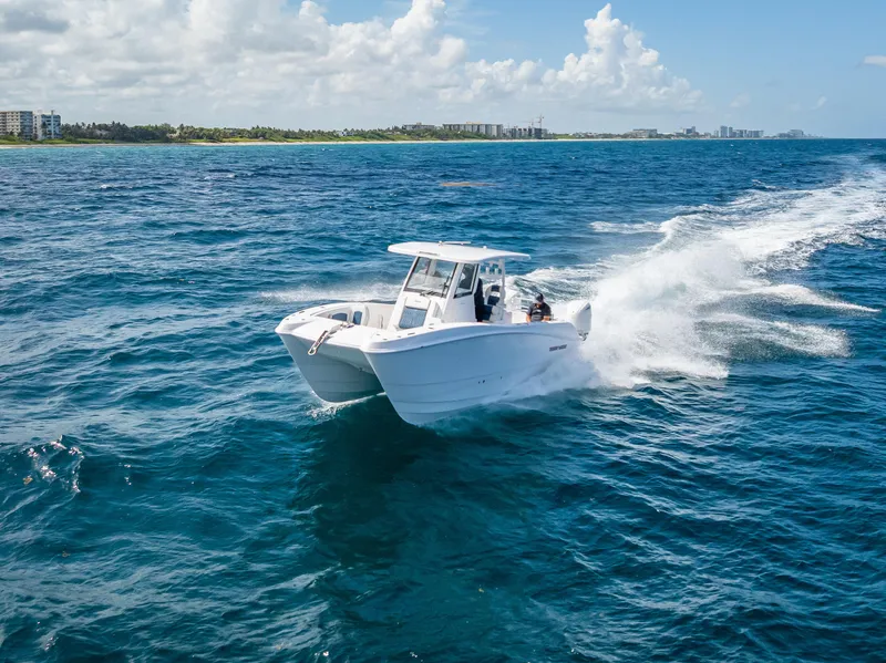 Slide: The Image of 2026 Twin Vee 260 GFX2 CC cruising on open ocean near coastline. - 7