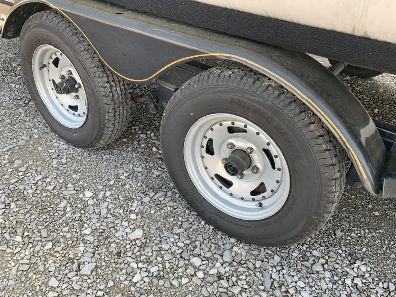 Slide: The Image of Trailer wheels of a 2007 Sun Tracker Party Barge 22 on gravel surface. - 10