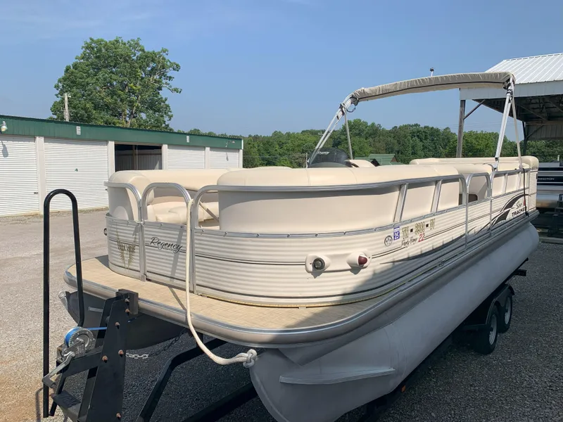 Slide: The Image of 2007 Sun Tracker Party Barge 22 pontoon boat on trailer, parked outdoors. - 4