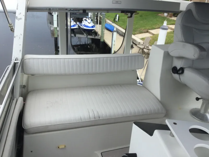 Slide: The Image of 1995 Carver 430 Cockpit Motor Yacht interior with white seating and helm chair. - 13