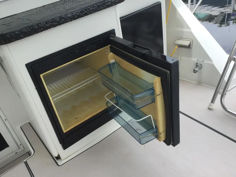 Slide: The Image of Open fridge on 1995 Carver 430 Cockpit Motor Yacht, showing interior shelves and door compartments. - 24