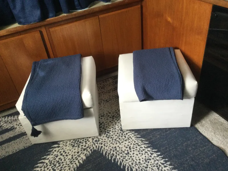 Slide: The Image of Two white ottomans with blue throws on a patterned carpet in a 1995 Carver 430 yacht. - 27