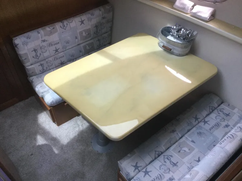 Slide: The Image of 1995 Carver 430 Cockpit Motor Yacht dining area with nautical-themed seating and table. - 29