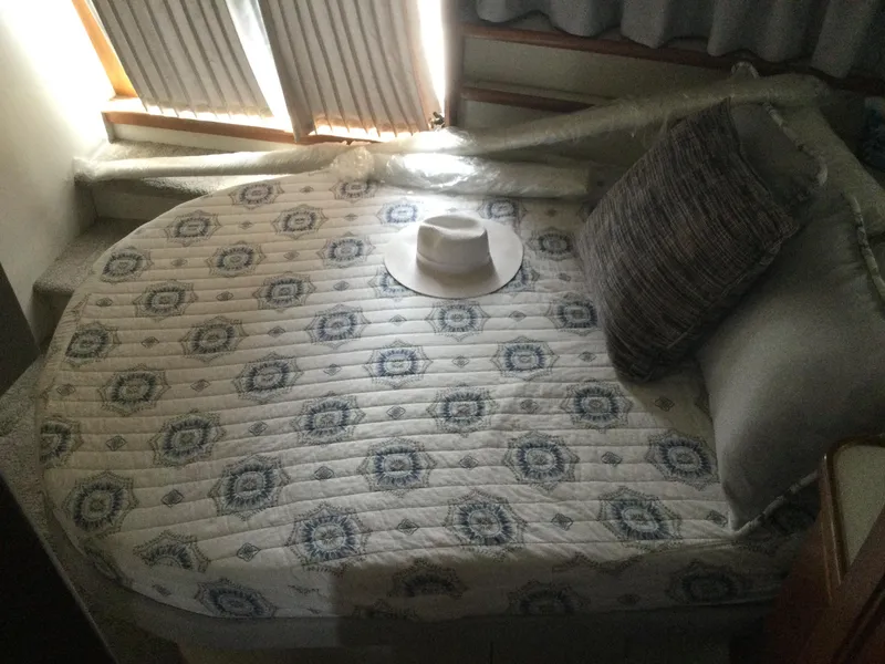 Slide: The Image of Cozy cabin bed in 1995 Carver 430 Cockpit Motor Yacht with patterned bedding and hat. - 39