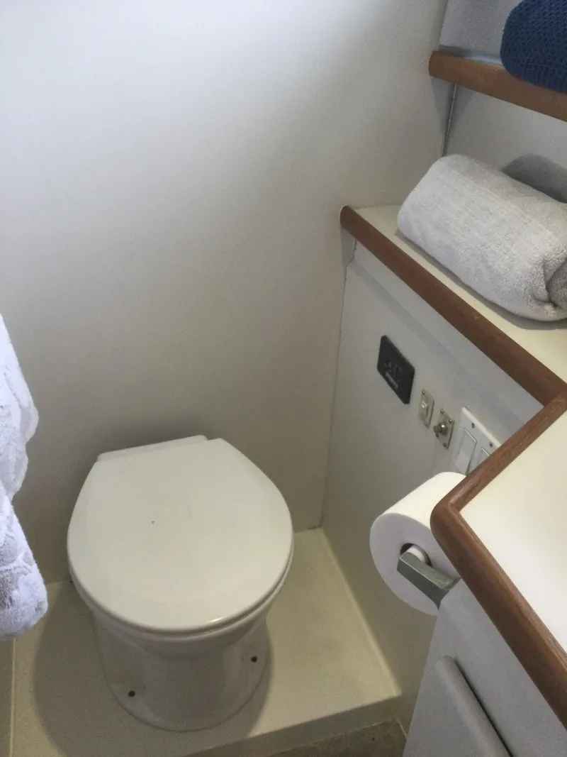 Slide: The Image of 1995 Carver 430 Cockpit Motor Yacht bathroom with toilet and towel storage. - 44