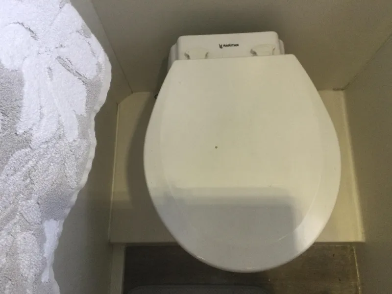 Slide: The Image of Toilet in 1995 Carver 430 Cockpit Motor Yacht bathroom, featuring a white seat and floral towel. - 48