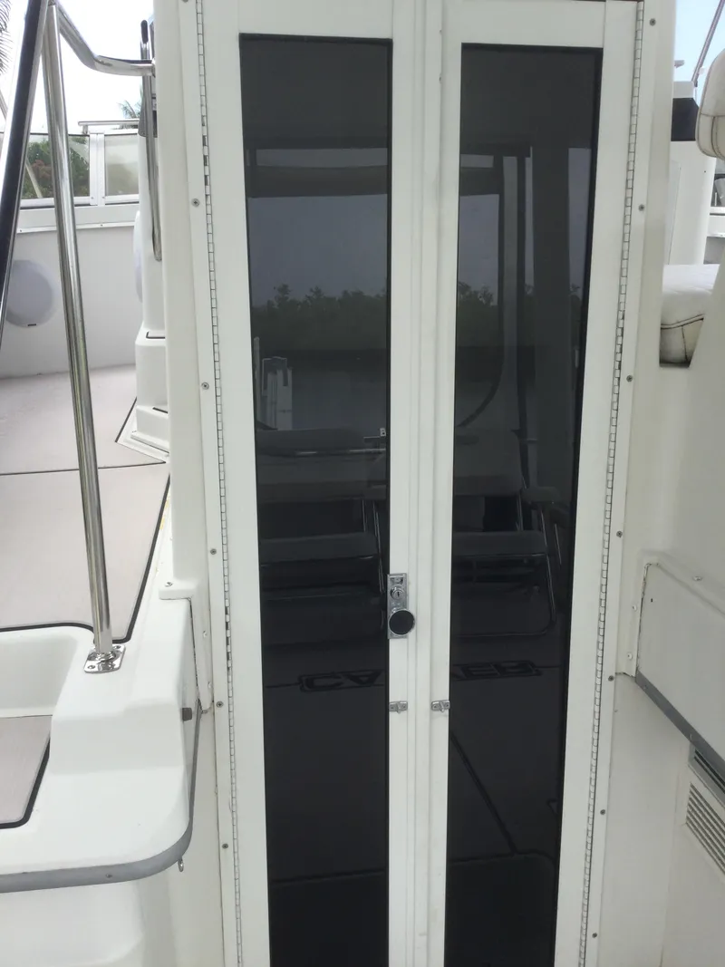 Slide: The Image of Glass doors on a 1995 Carver 430 Cockpit Motor Yacht, showcasing sleek design. - 7
