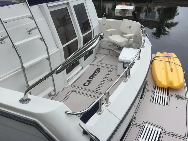 Slide: The Image of 1995 Carver 430 Cockpit Motor Yacht with deck seating and yellow kayak. - 1
