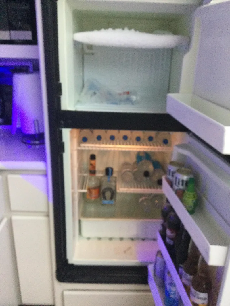 Slide: The Image of Open refrigerator inside 1995 Carver 430 Cockpit Motor Yacht, stocked with beverages and condiments. - 16