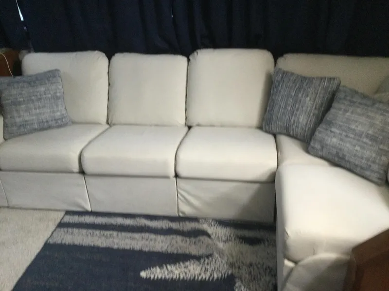 Slide: The Image of White sofa with blue cushions in a cozy setting, aboard a 1995 Carver 430 Cockpit Motor Yacht. - 22