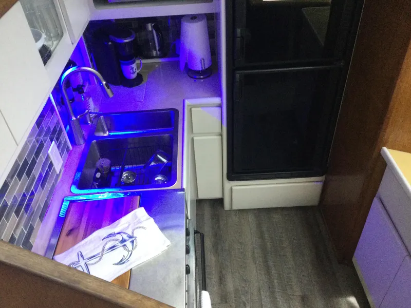 Slide: The Image of Interior of 1995 Carver 430 Cockpit Motor Yacht kitchen with modern amenities and blue lighting. - 28