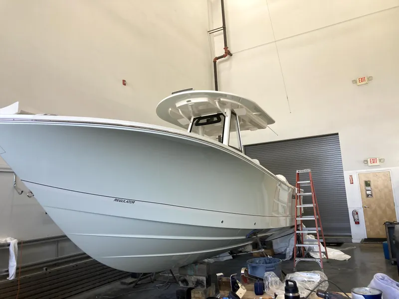 Slide: The Image of 2023 Regulator 28 Forward Seating boat in a workshop, side view. - 0