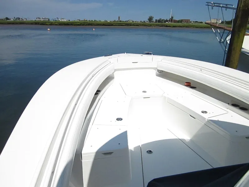 Slide: The Image of 2023 Regulator 28 Forward Seating boat on calm water, showcasing spacious deck design. - 12