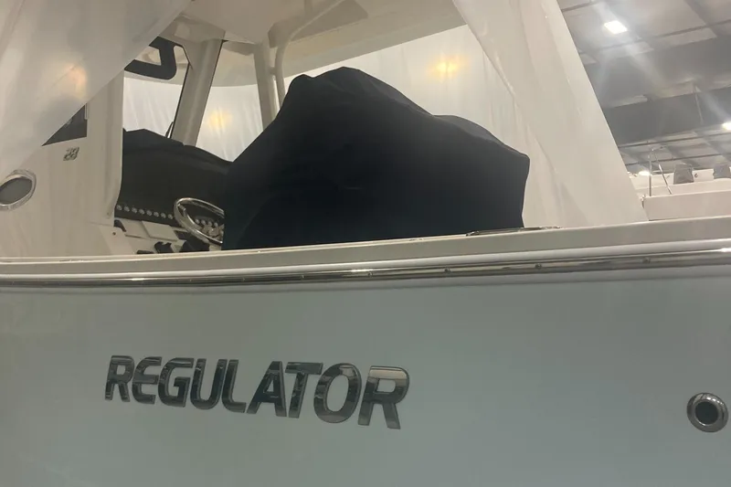 Slide: The Image of 2023 Regulator 28 Forward Seating boat in showroom, side view with logo. - 9