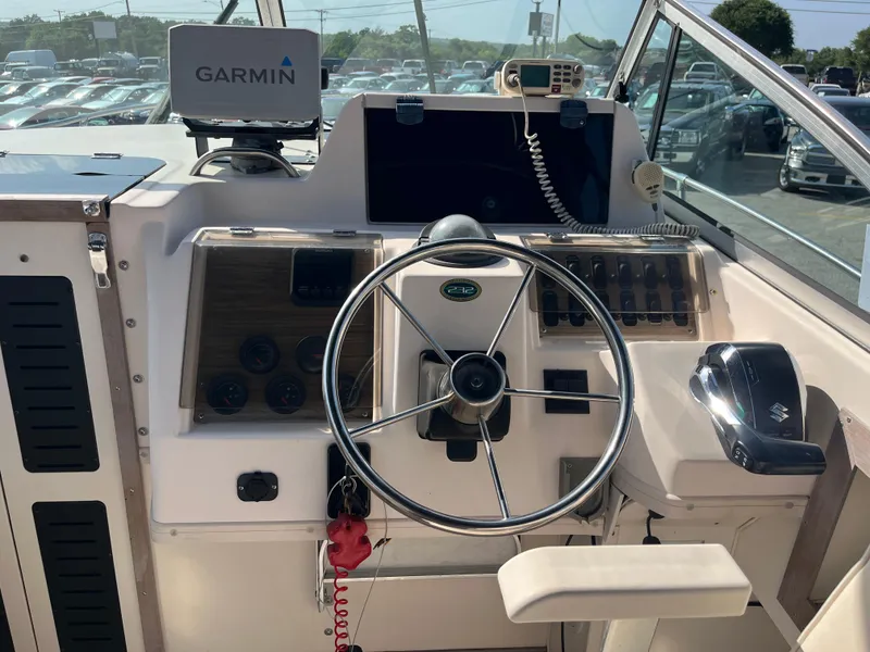 Slide: The Image of 1997 Grady-White 232 Gulfstream boat dashboard with Garmin GPS and steering wheel. - 12