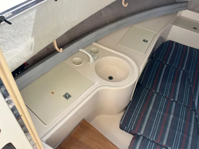 Slide: The Image of Interior of 1997 Grady-White 232 Gulfstream boat with sink and cushioned seating. - 14
