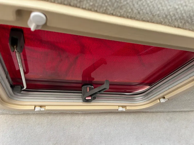 Slide: The Image of Red hatch window inside 1997 Grady-White 232 Gulfstream boat, featuring a secure latch mechanism. - 16