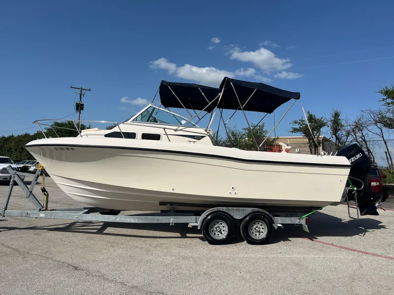 Slide: The Image of 1997 Grady-White 232 Gulfstream boat on trailer with Suzuki outboard motor. - 2