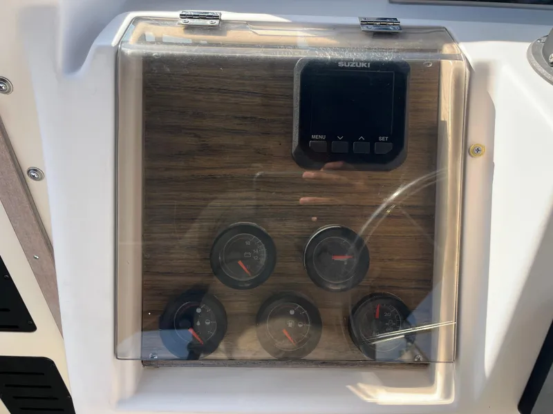 Slide: The Image of Dashboard of a 1997 Grady-White 232 Gulfstream boat with Suzuki controls and gauges. - 26