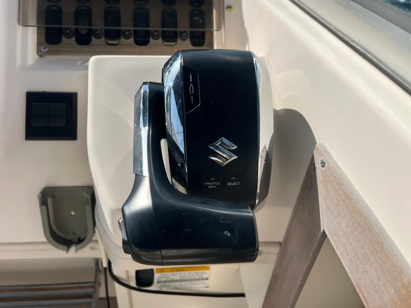 Slide: The Image of Throttle control of a 1997 Grady-White 232 Gulfstream boat with Suzuki branding. - 48
