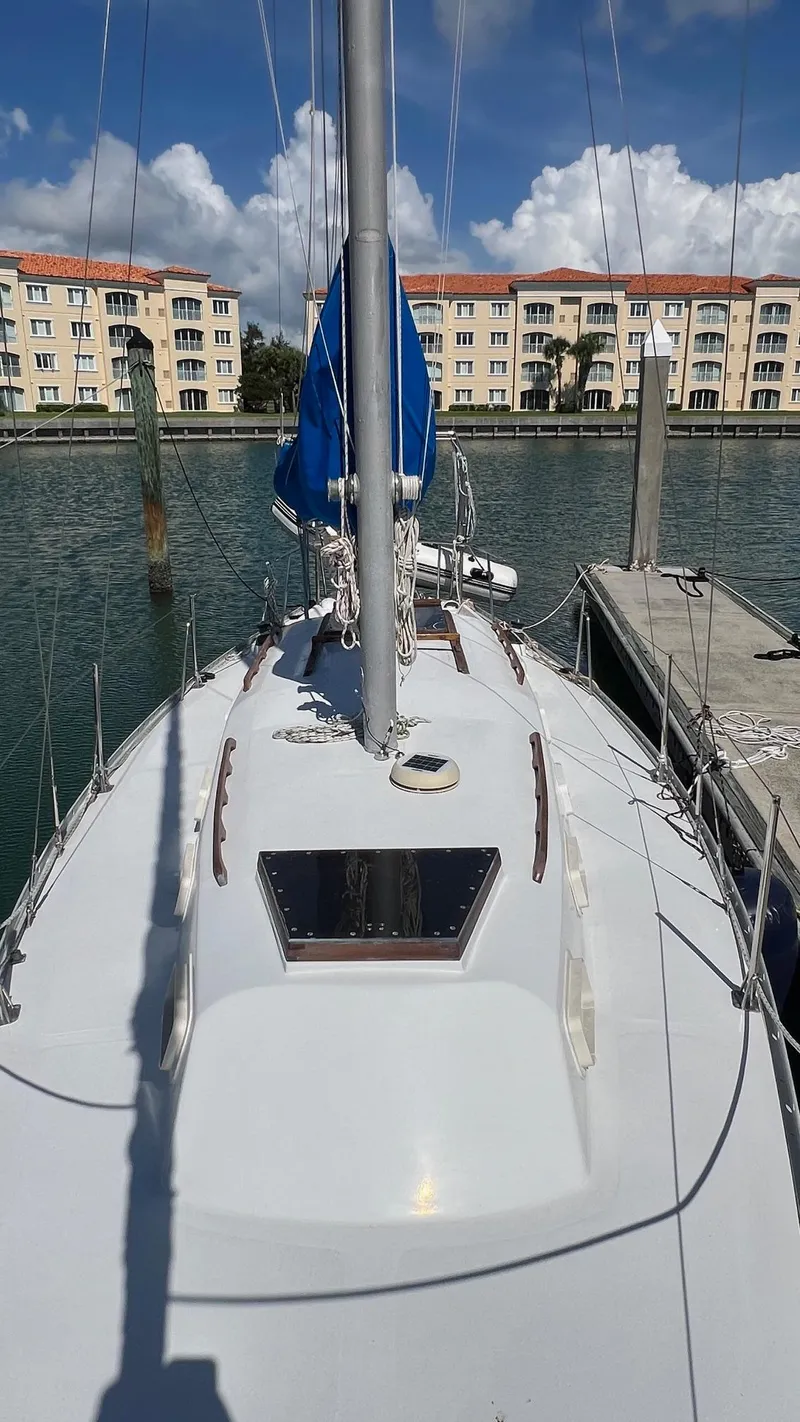 Slide: The Image of 1976 Endeavour 32' Sloop docked in marina with waterfront buildings in background. - 11