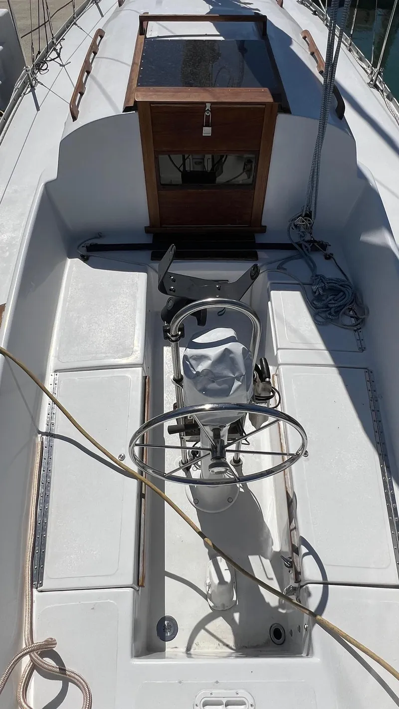Slide: The Image of 1976 Endeavour 32' Sloop cockpit with steering wheel and hatch, showcasing clean deck design. - 18