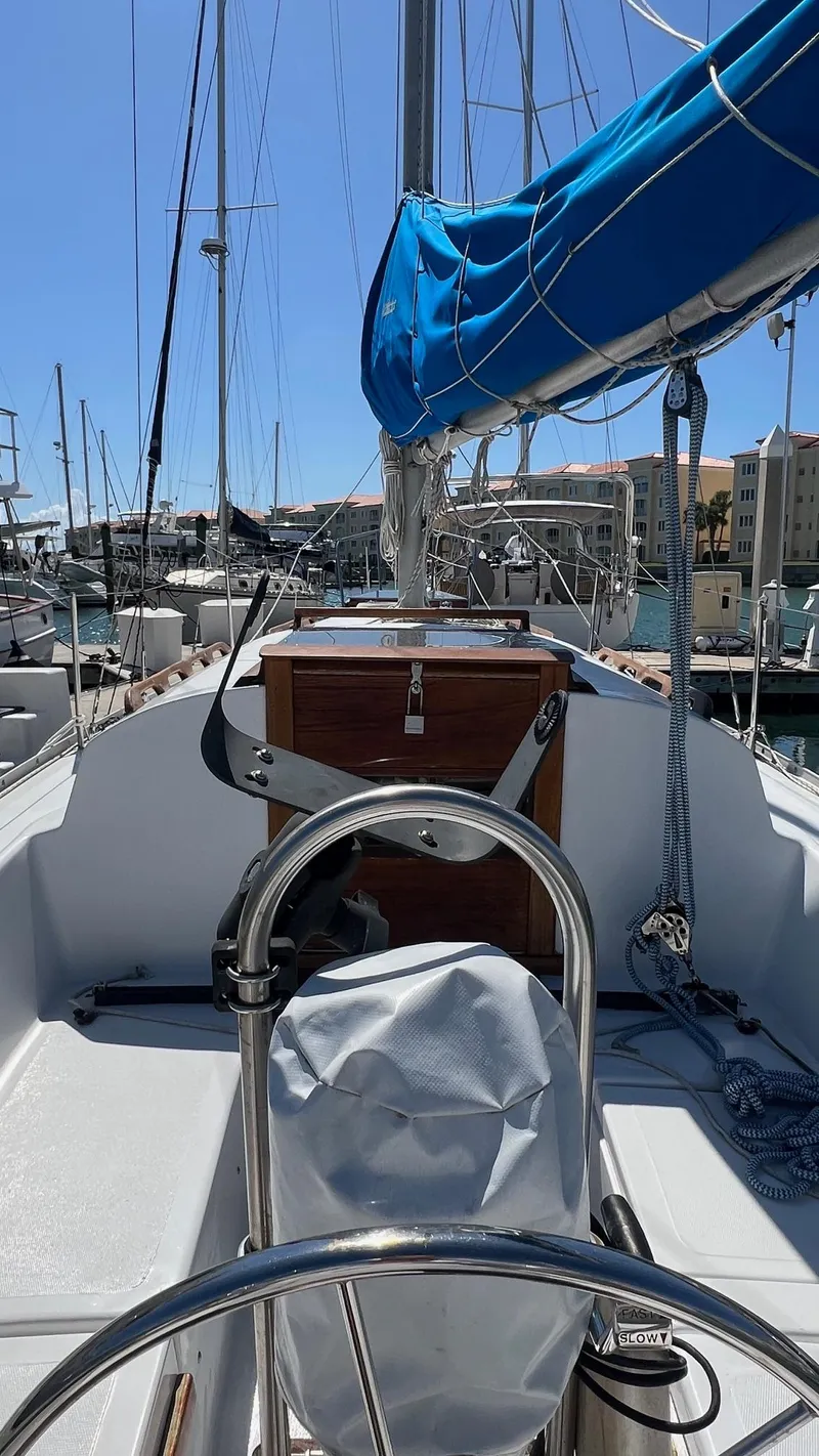 Slide: The Image of 1976 Endeavour 32' Sloop sailboat docked in a marina, featuring a blue sail cover. - 19