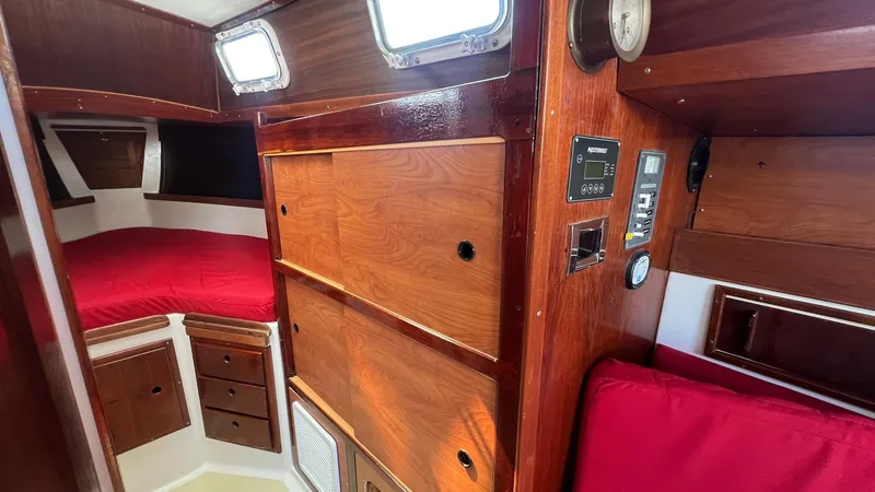 Slide: The Image of Interior of 1976 Endeavour 32' Sloop with wood paneling and red bedding. - 23