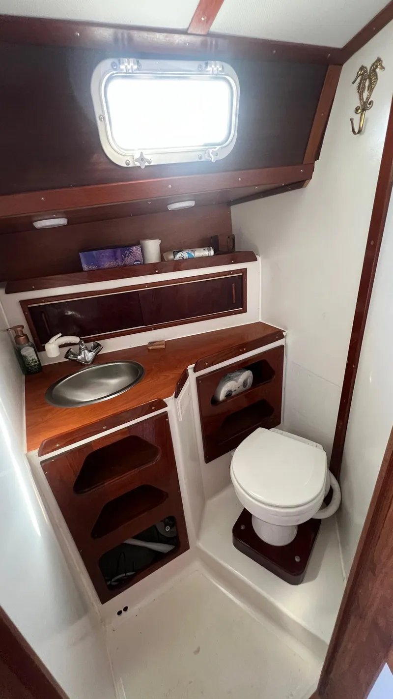 Slide: The Image of 1976 Endeavour 32' Sloop bathroom with wooden cabinetry, sink, and toilet. - 29